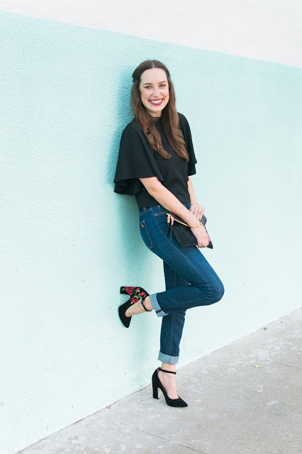 Black Lace & Embroidered Heels featured by top Houston fashion blog, Lone Star Looking Glass: image of a woman wearing Henri Bendel clutch, anthropologie embroidered heels, MIH jeans and Francesca’s Black lace Blouse