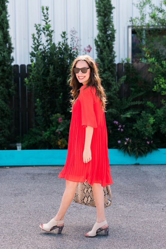 Maternity outfit inspiration with a red dress and snake print accessories.