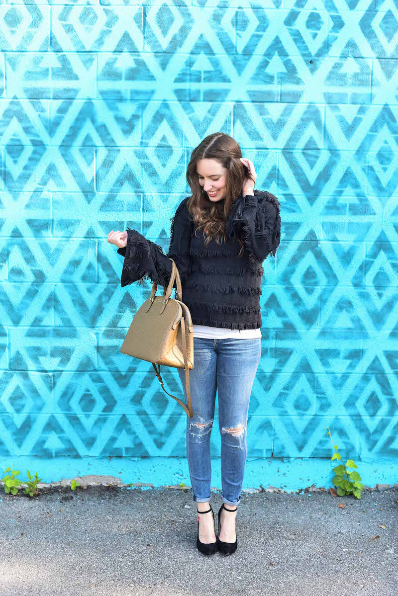 Houston Fashion Blogger Lone Star Looking Glass styles Yoana Baraschi's black fringed sweater with distressed citizen jeans and Henri Bendel's Ostrich Dome Satchel.
