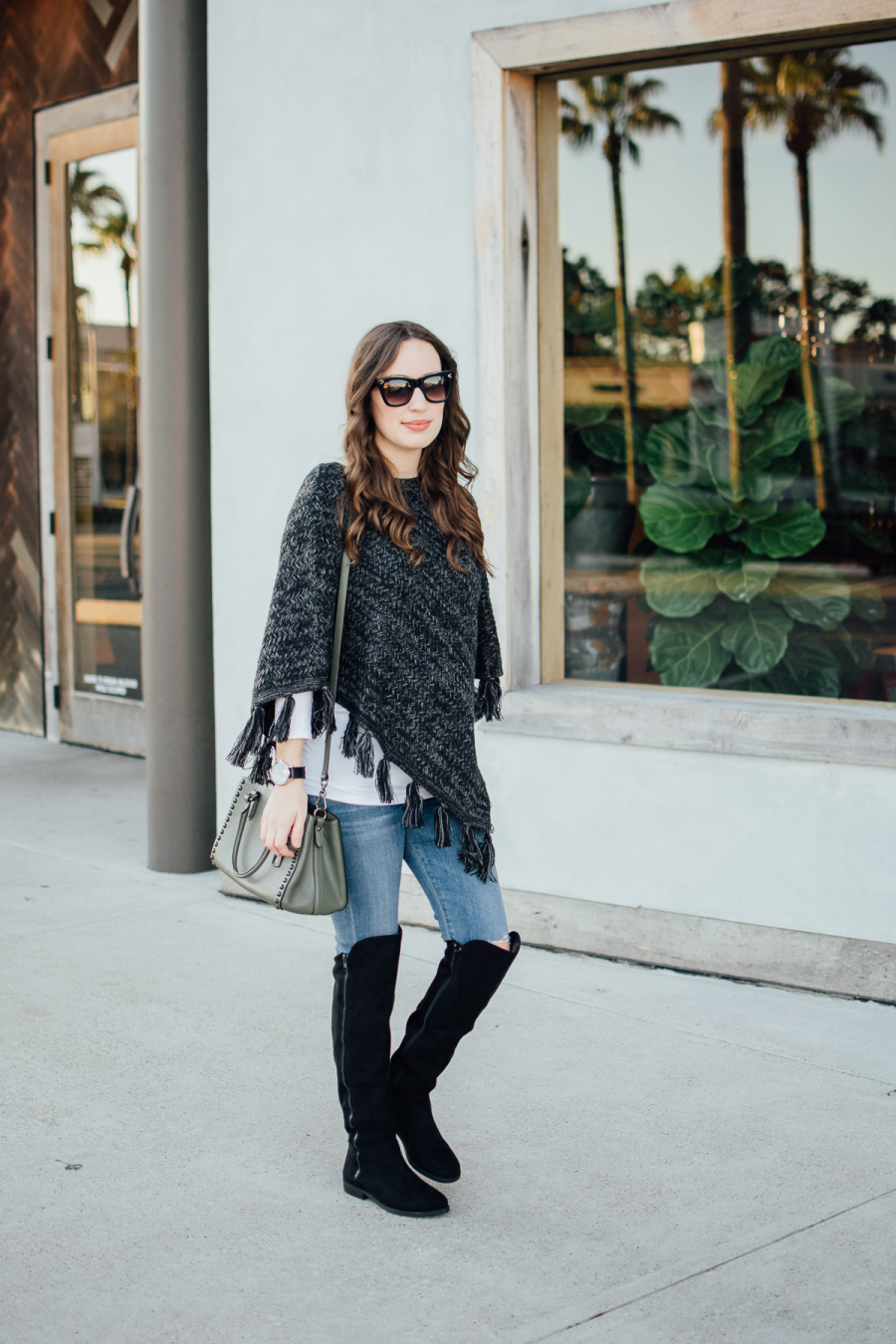 Texas blogger shares fall outfit inspiration with a fringe poncho and black over the knee boots from Macy's and Style&Co.