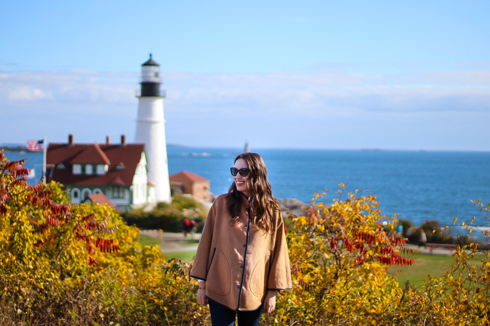New England outfit inspiration with a J. McLaughlin poncho at Portland Head Light in Maine.