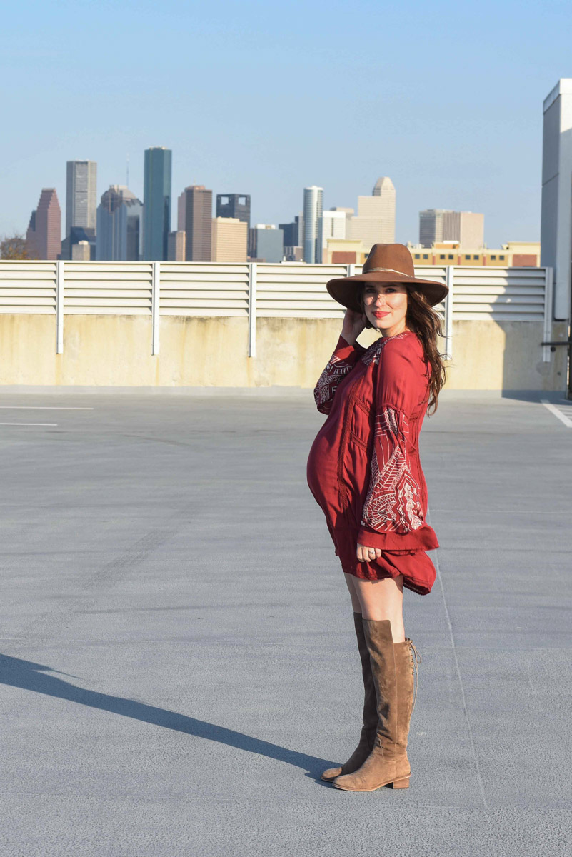 Houston fashion blogger Alice Kerley styles a Planet Blue bohemian red mini dress as a maternity dress with a pair of Elaine Turner suede over the knee boots.