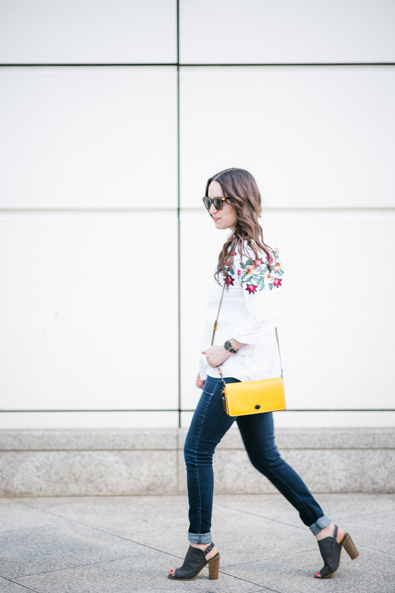 Houston fashion blogger styles embroidered White Button down styled with skinny jeans and the coach dinky bag in yellow.