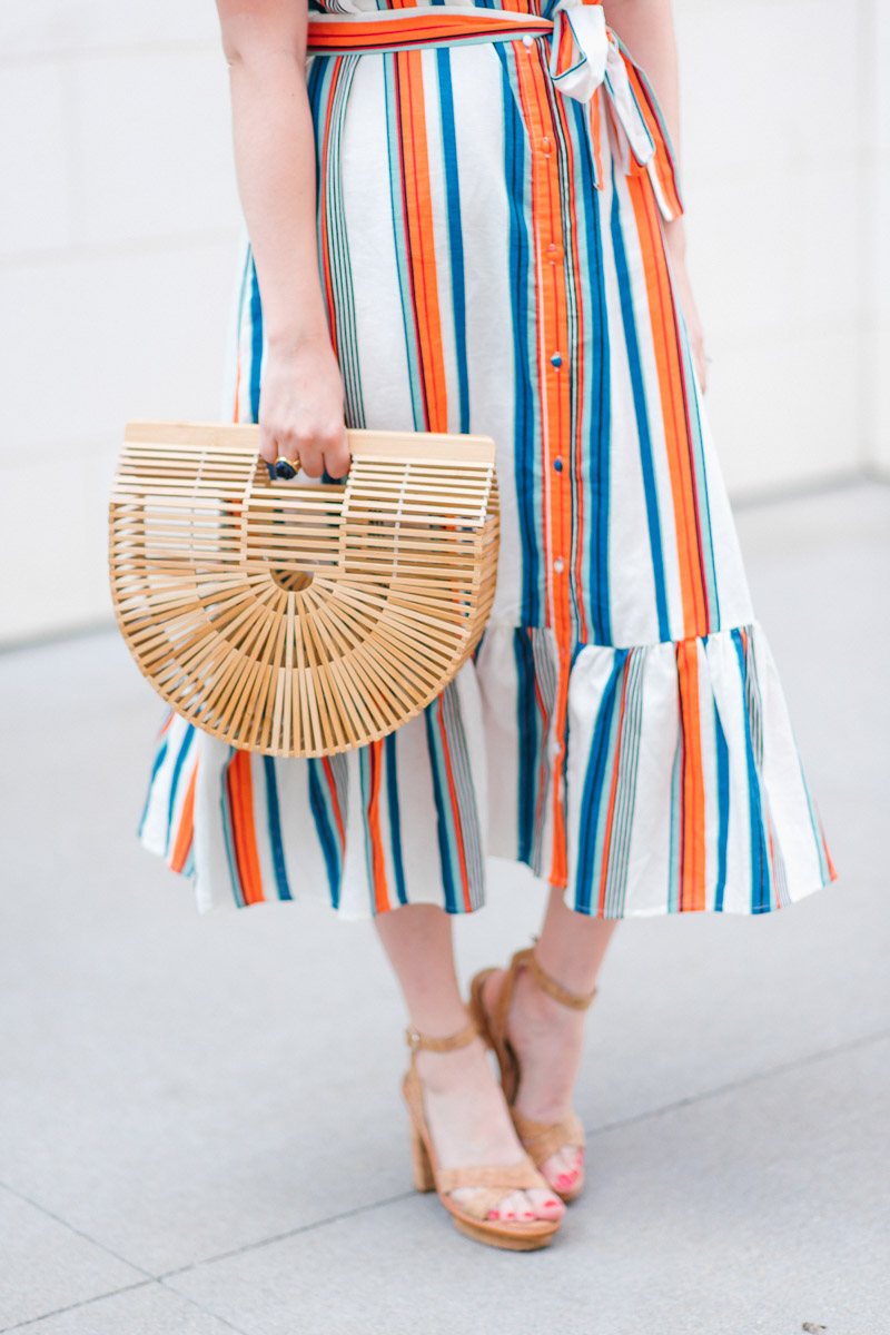 Houston blogger styles a striped moon river off the shoulder dress with a Cult Gaia bag.
