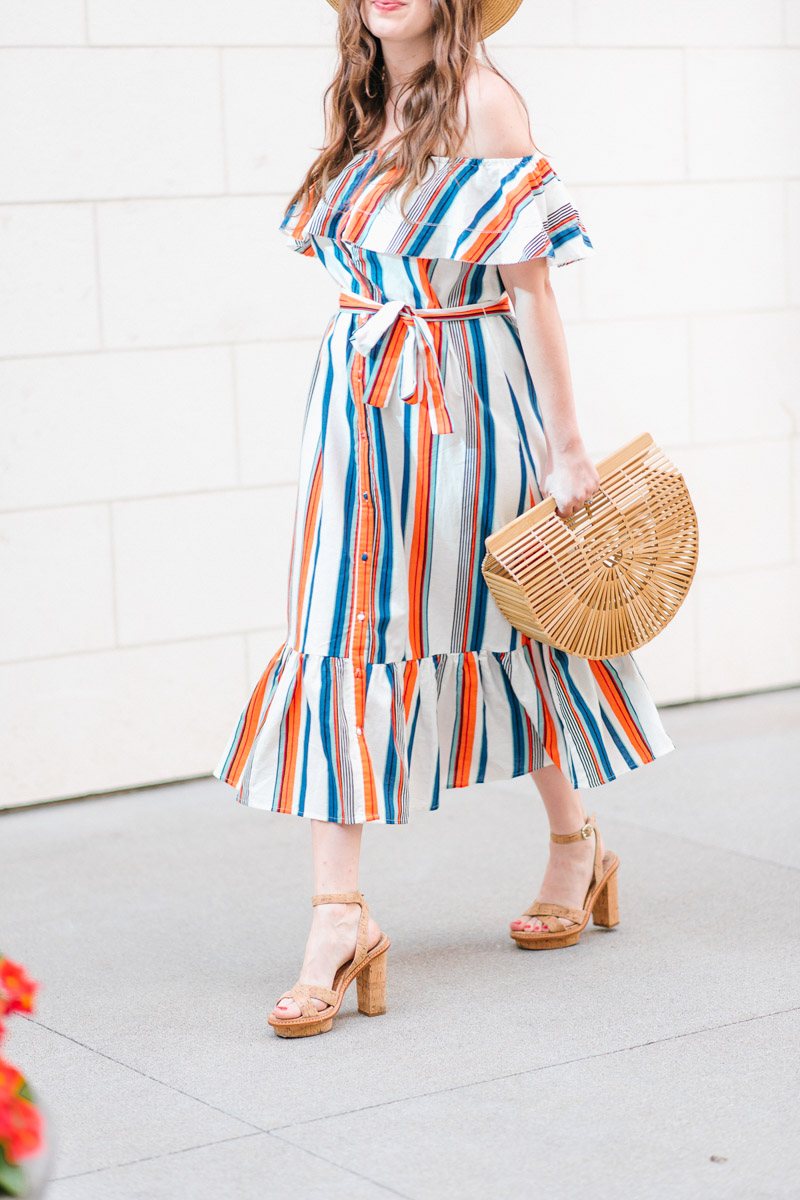 Houston blogger styles a striped moon river off the shoulder dress with a Cult Gaia bag.