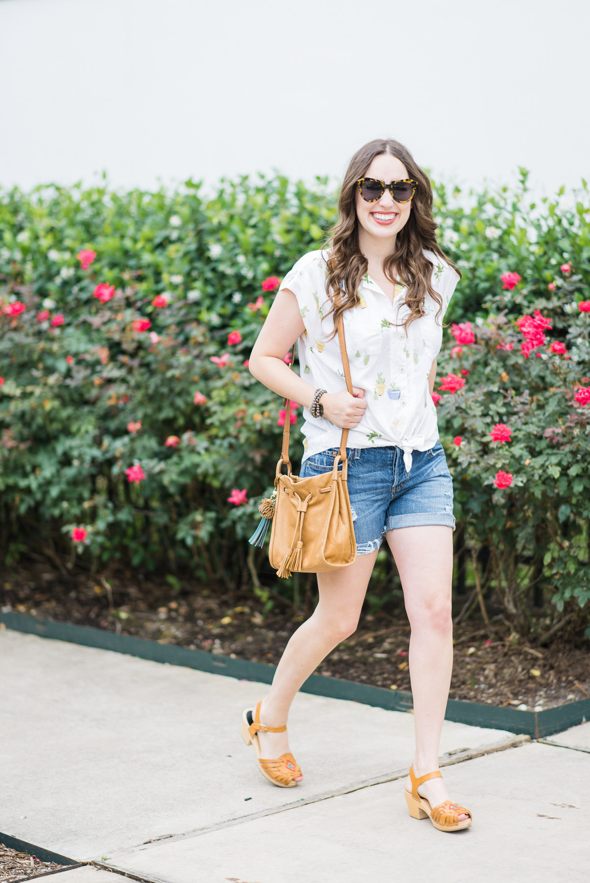 Houston blogger styles an easy summer look in an Anthropologie cactus button down, levi shorts, swedish hasbeens and a fossil handbag.