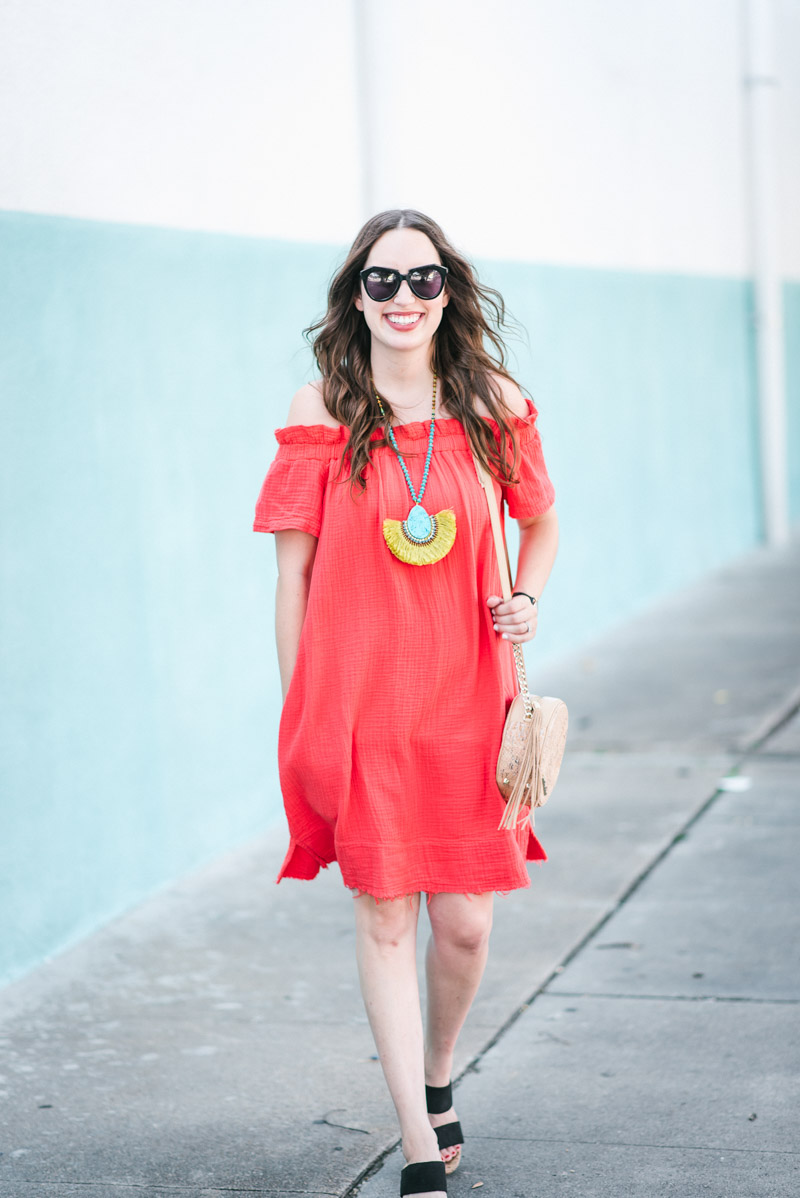 Red off the shoulder anthropolgoie dress styled with a turquoise fringe statement necklace.