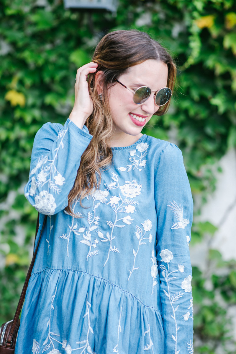 Anthropologie circle sunglasses paired with a blue and white embroidered sundress.