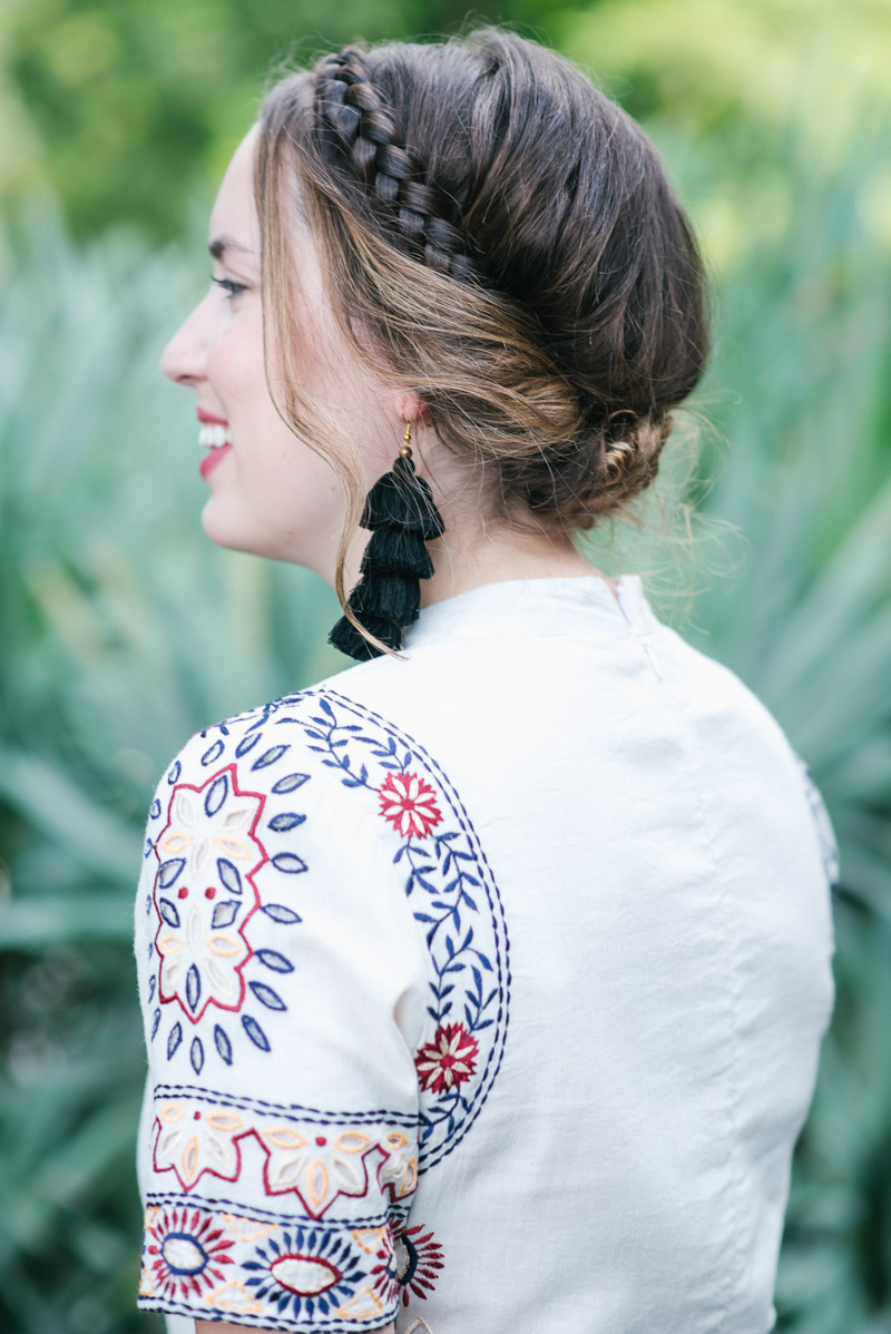 Texas fashion blogger styles a boho crown braid hairstyle with black tassel earrings.