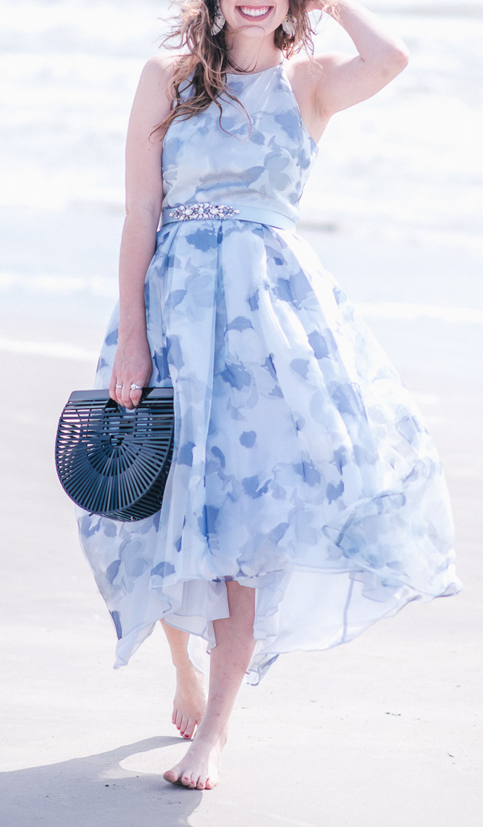 Spring Wedding Guest Dresses featured by top US fashion blog Lone Star Looking Glass; Image of a woman wearing Eliza J Blue Floral Halter Dress