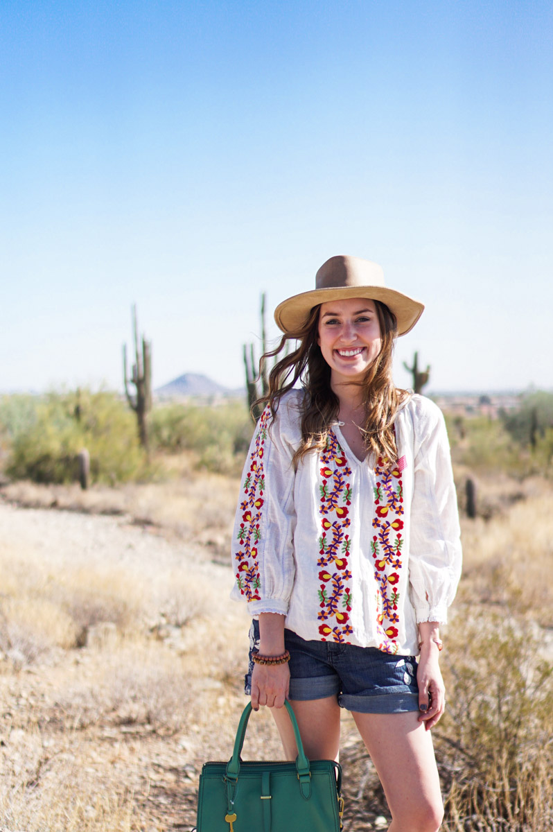 Phoenix Travel Guide featured by top Houston travel blog, Lone Star Looking Glass: image of a woman wearing an embroidered shirt, denim shorts, green bag and a panama hat at Taliesin West