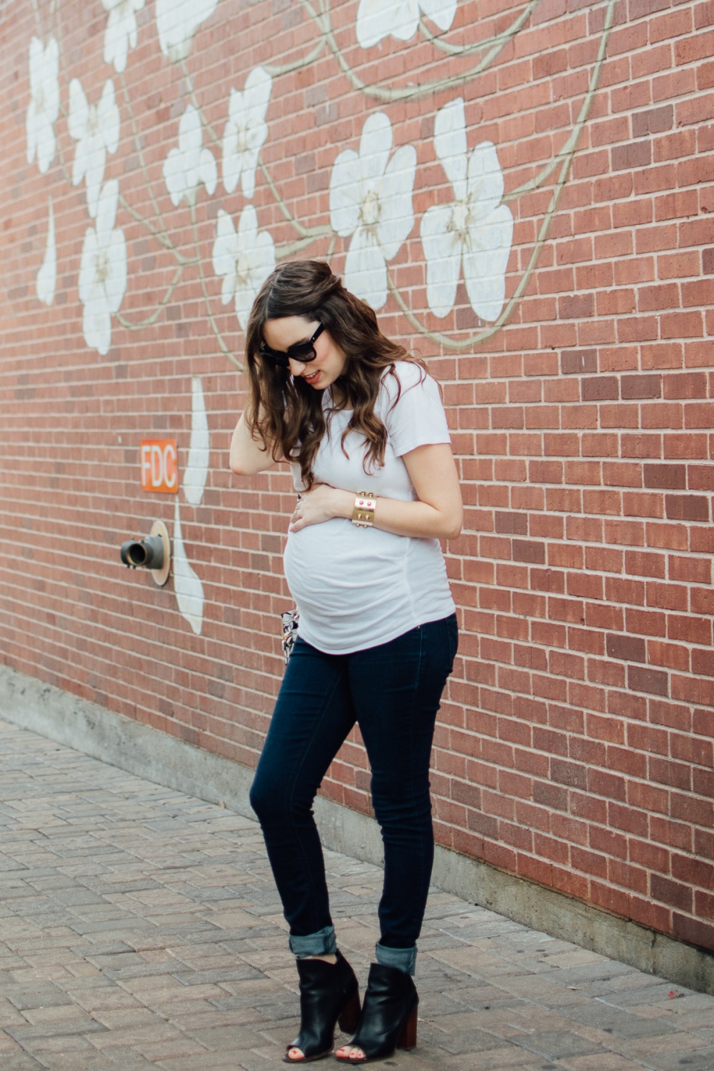 Texas fashion blogger Lone Star Looking Glass shares maternity outfit inspiration in a white tee, jeans and a Kate Spade Floral Handbag.