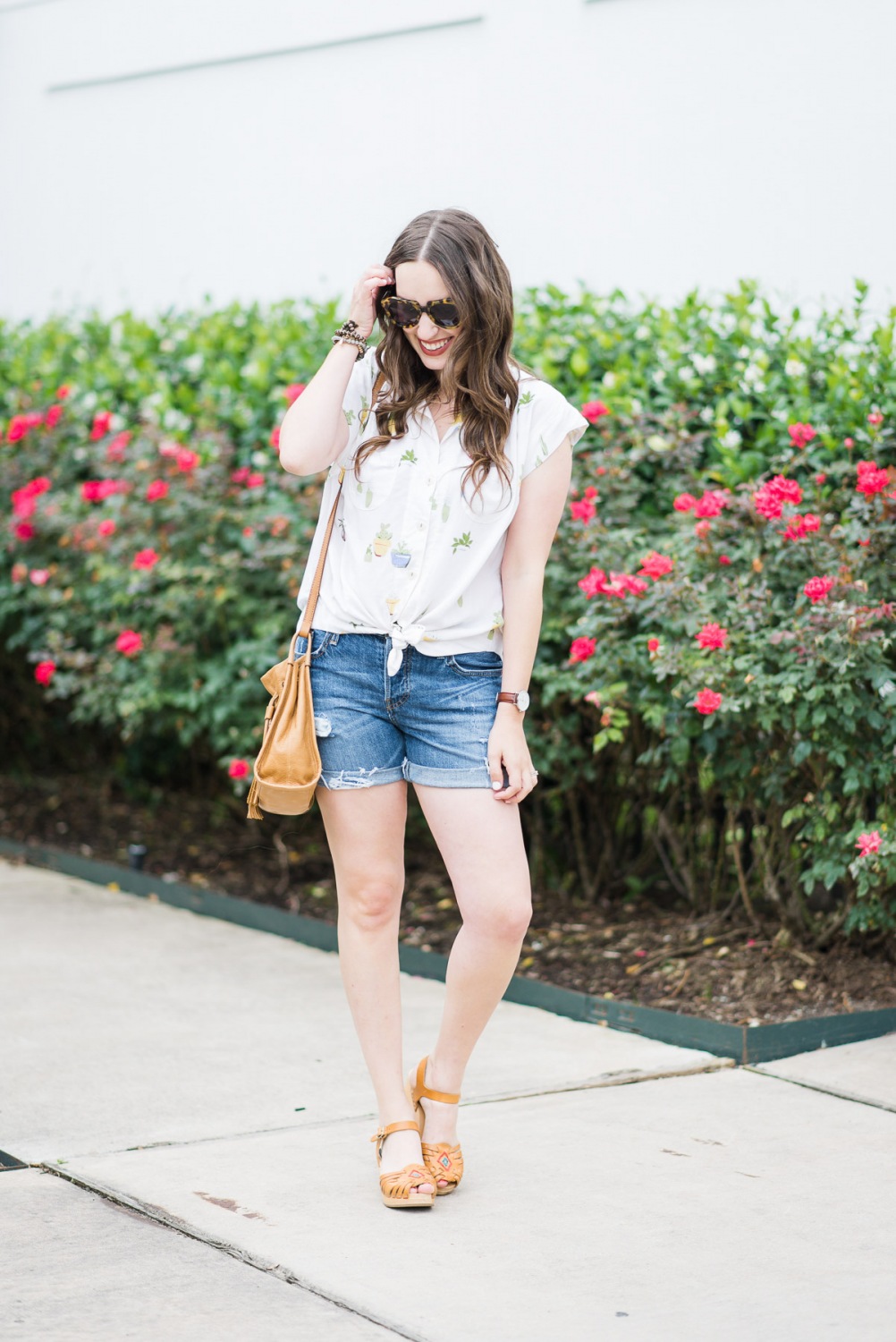 Houston blogger styles an easy summer look in an Anthropologie cactus button down, levi shorts, swedish hasbeens and a fossil handbag.