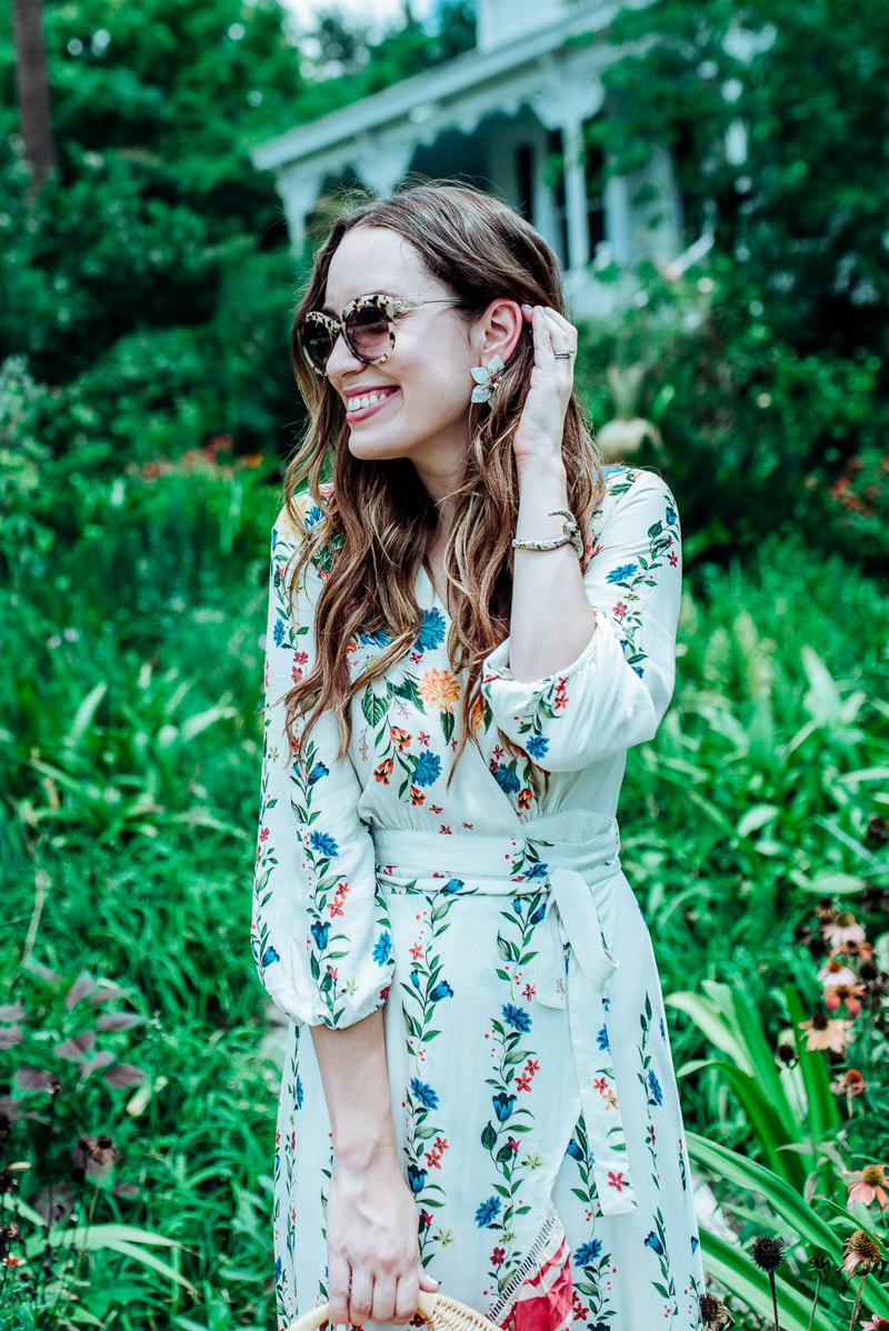 Floral Maxi Dress featured by top US fashion blog Lone Star Looking Glass; Image of a woman wearing an Anthropologie floral maxi dress, Baublebar stud earrings, Anthropologie cat eye sunglasses, Ann Taylor sandals and J McLaughlin wicker circular bag.