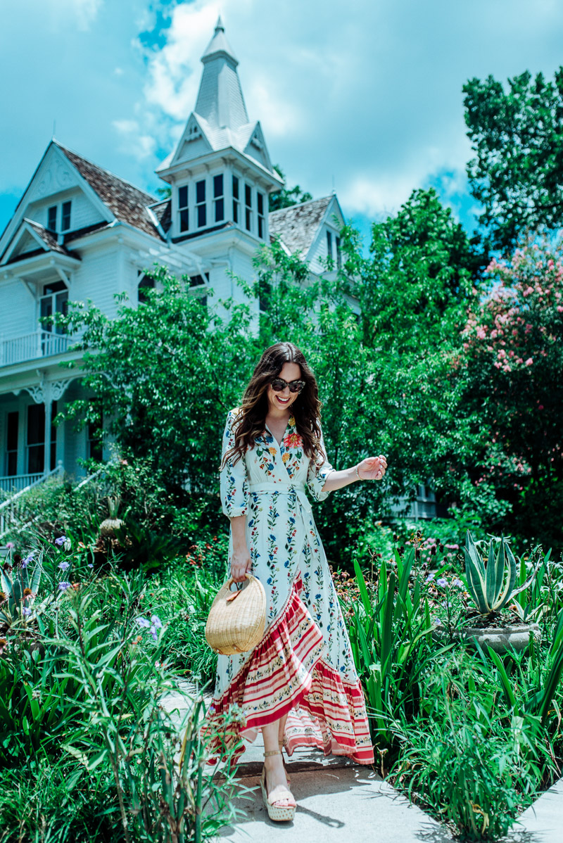 Floral Maxi Dress featured by top US fashion blog Lone Star Looking Glass; Image of a woman wearing an Anthropologie floral maxi dress, Baublebar stud earrings, Anthropologie cat eye sunglasses, Ann Taylor sandals and J McLaughlin wicker circular bag.