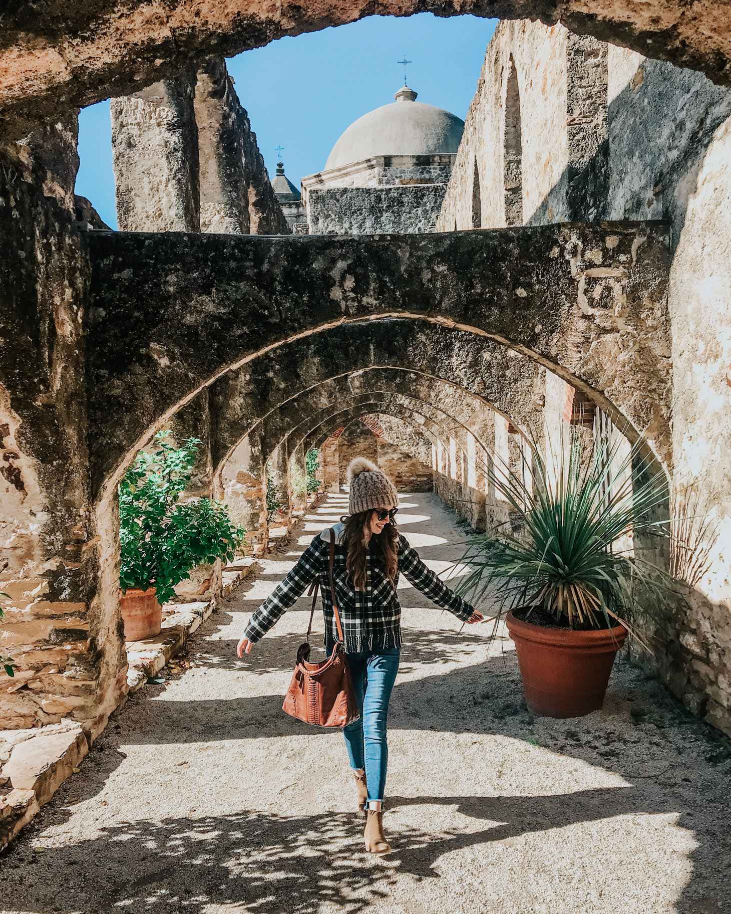 San Antonio in Winter featured by top US travel blog Lone Star Looking Glass; Image of woman walking under arch