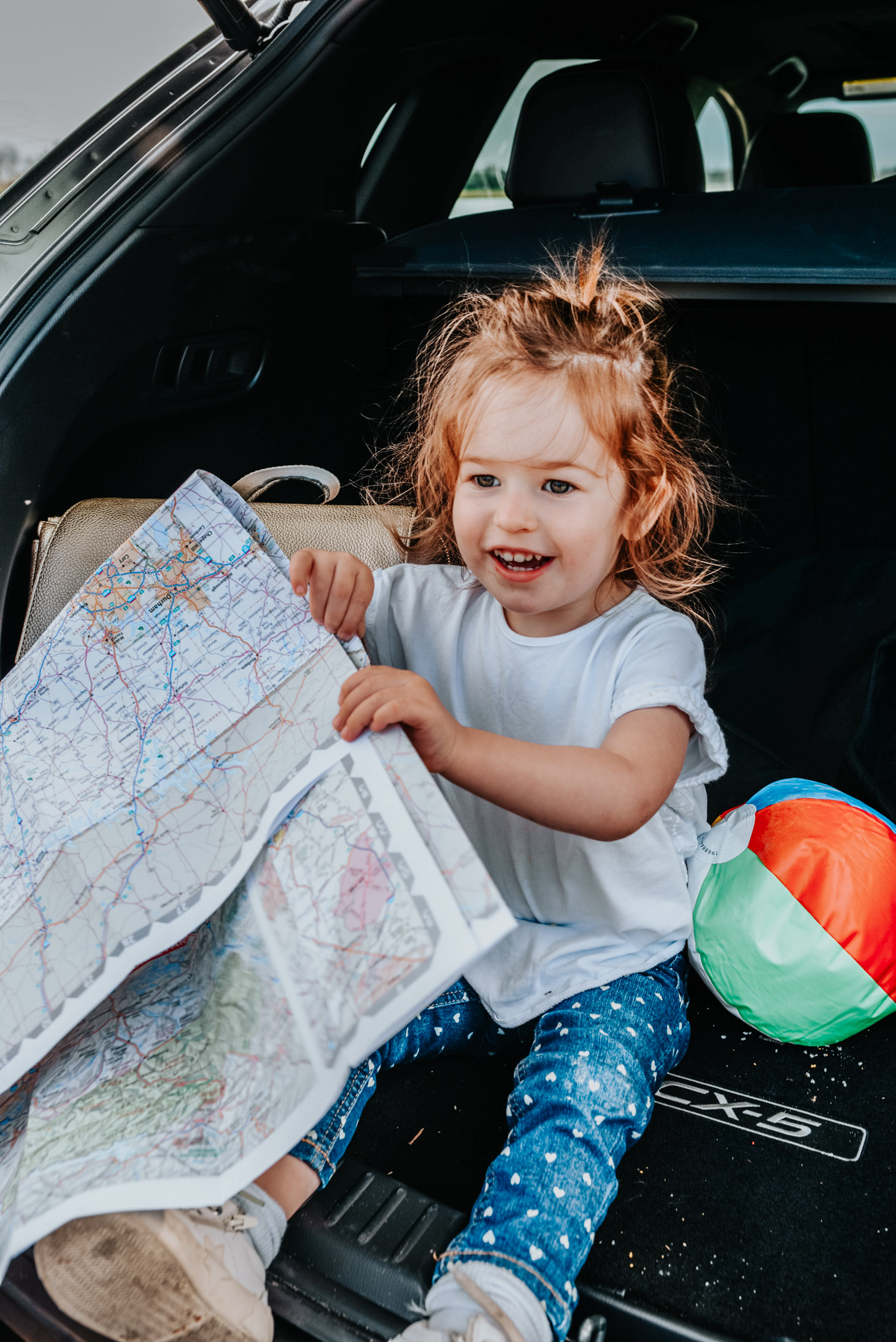10 Essential Tips for your Next Road Trip with a Toddler featured by top US travel blog, Lone Star Looking Glass: image of a toddler holding a road map