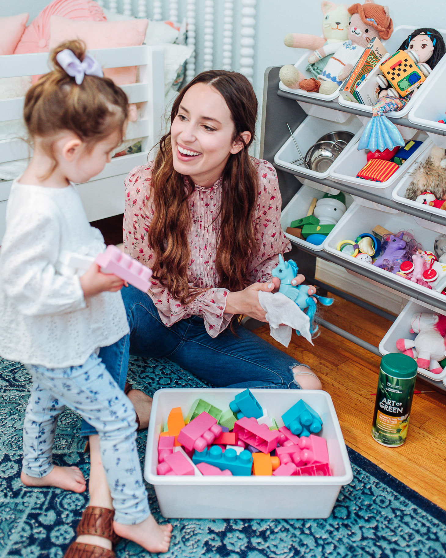 Essential Green Spring Cleaning Tips featured by top US lifestyle blog, Lone Star Looking Glass: image of a woman cleaning toys with Art of Green cleaning products