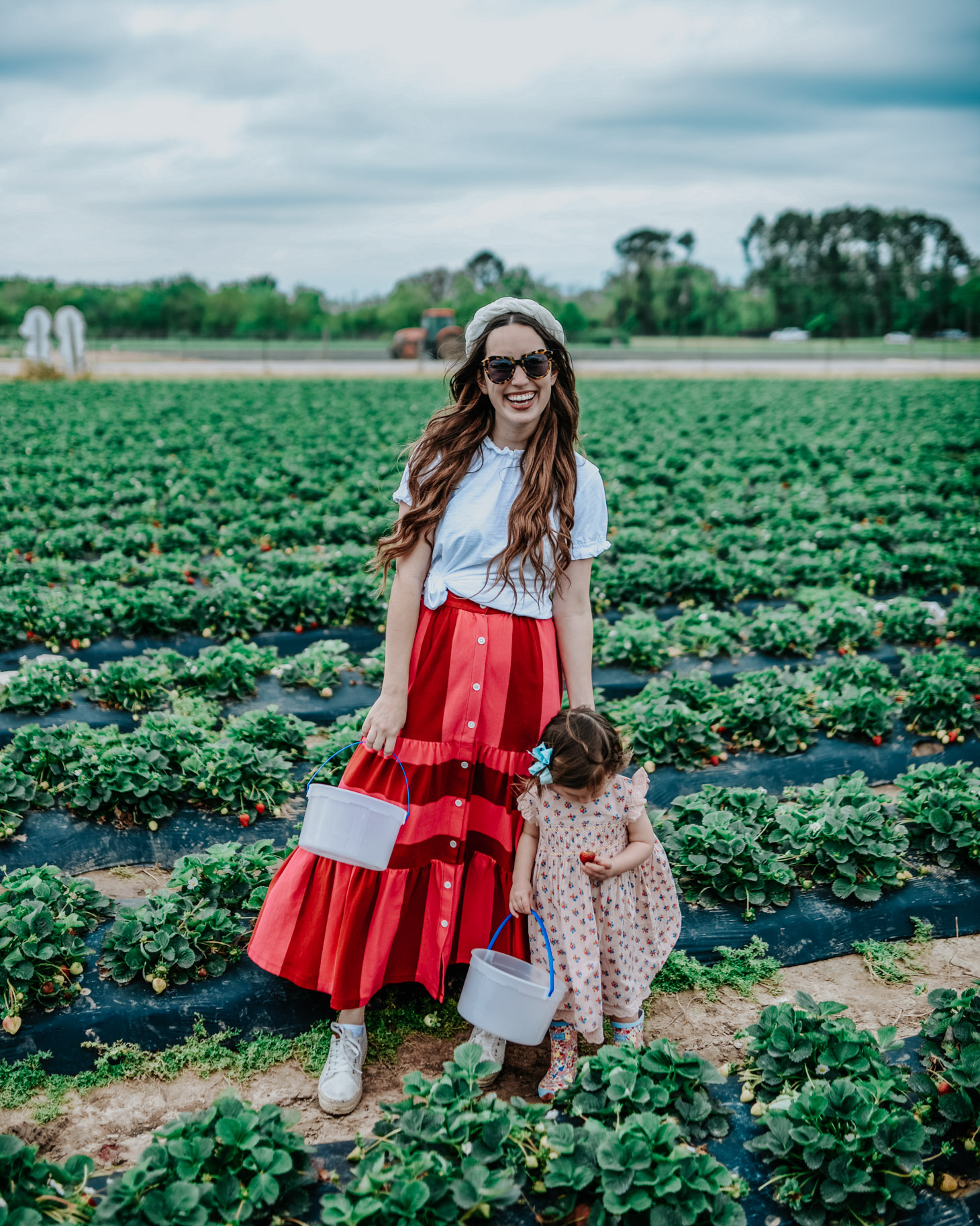  Where to Go Strawberry Picking in Houston: a review of strawberry picking at Froberg’s Farms featured by top US travel blog, Lone Star Looking Glass: image of a woman wearing a Rent the Runway colorblock maxi skirt, Anthropologie top and headband, Tretorn espadrille sneakers and her little girl