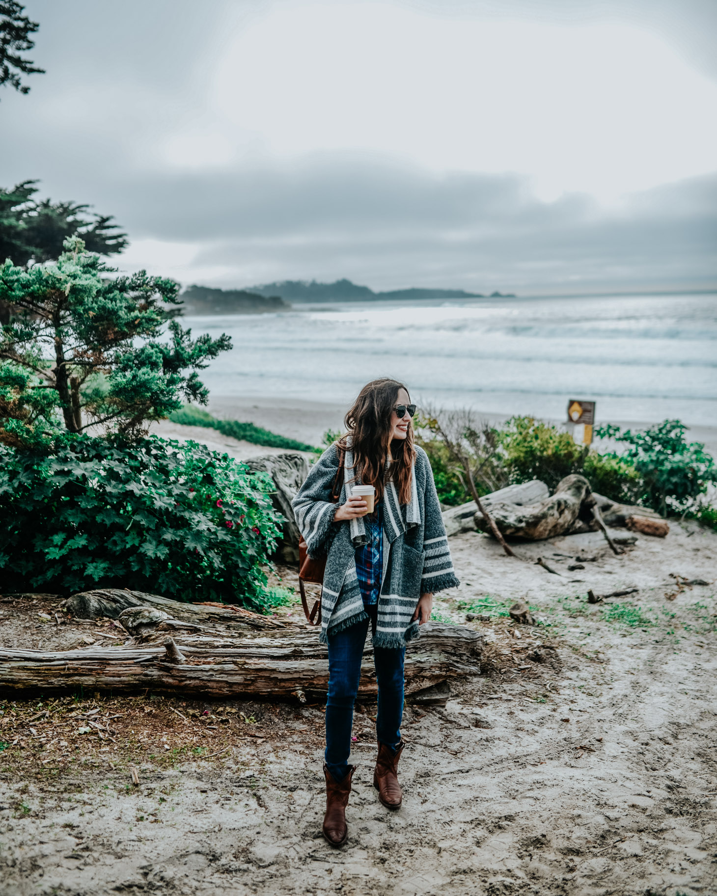 The Best Things to Do in Carmel By-the-Sea featured by top US travel and fashion blog, Lone Star Looking Glass: image of a woman wearing a Treasure & Bond plaid shirt, Anthropologie Kimono, Levi’s 721 ripped skinny jeans, Tecova cowgirl booties, and a Patricia Nash hobo bag