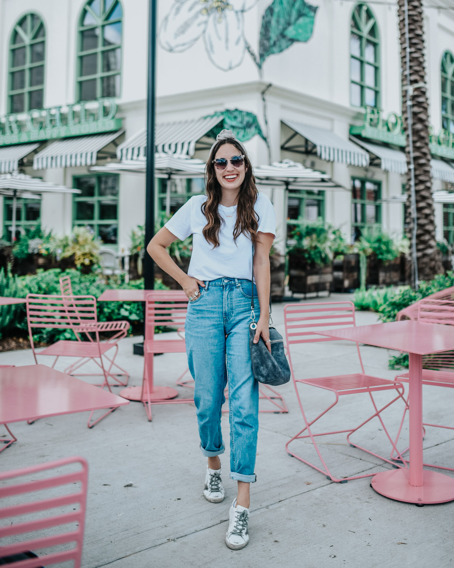 Basic Wardrobe Essentials for every mom featured by top US fashion blog, Lone Star Looking Glass: image of a woman wearing Everlane Straight jeans, Golden Goose sneakers, a knot headband, a crossbody bag and an Everlane white tee.