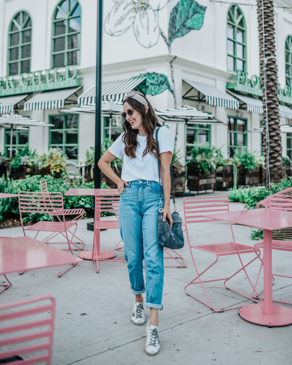 Basic Wardrobe Essentials for every mom featured by top US fashion blog, Lone Star Looking Glass: image of a woman wearing Everlane Straight jeans, Golden Goose sneakers, a knot headband, a crossbody bag and an Everlane white tee.