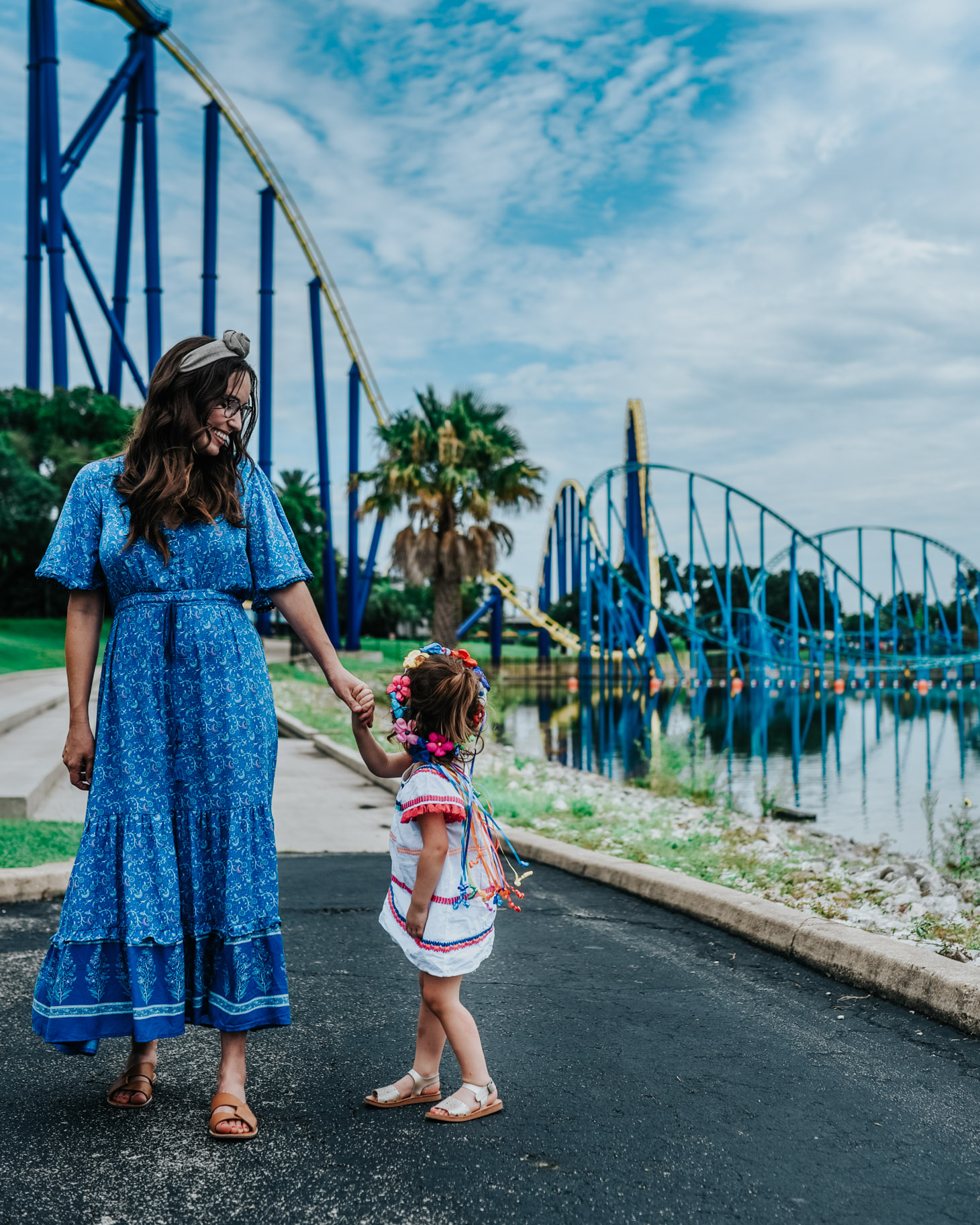 Top 10 Kid Friendly Activities in San Antonio by popular Texas travel blog, Lone Star Looking Glass: image of a mom and her two year old daughter standing next to a roller coaster at Sea World San Antonio.