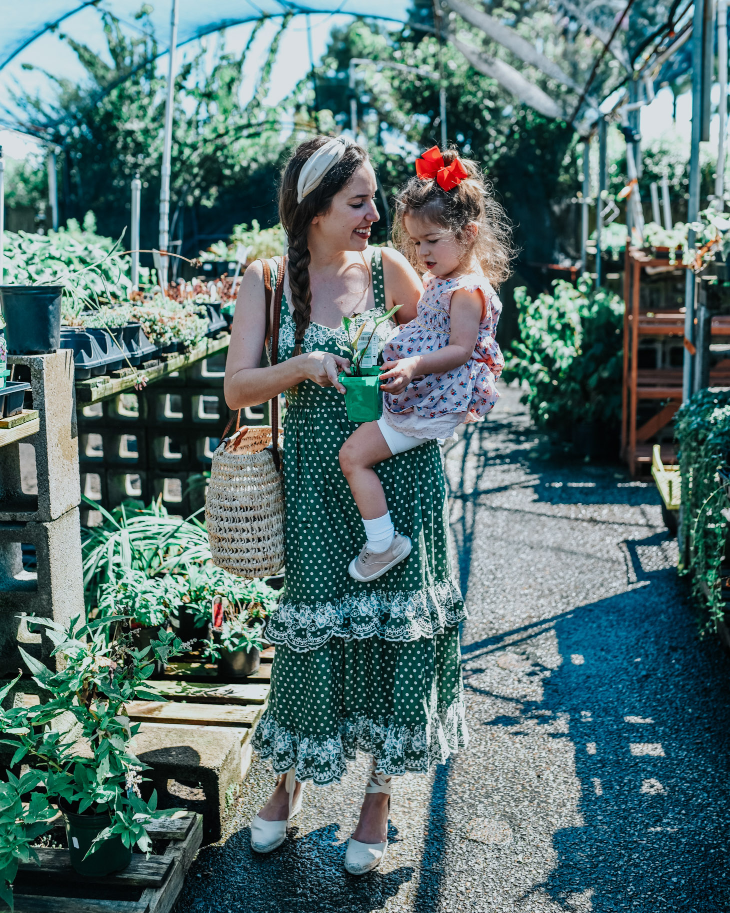 5 Dress Designers to Take Note Of this Summer by popular Memphis fashion blog, Lone Star Looking Glass: image of a woman holding her daughter in a greenhouse and wearing a Tularosa Landry Dress.
