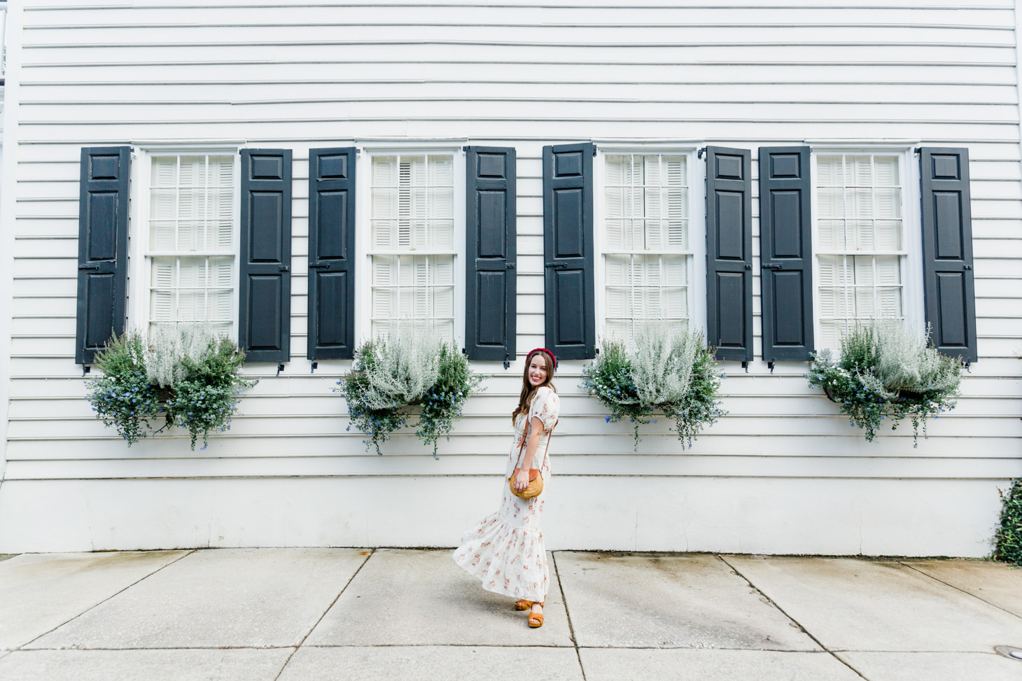 The New Southern Living Tastemaker, featured by top US life and style blog, Lone Star Looking Glass: image of a woman wearing a LoveShackFancy floral maxi dress, Patricia Nash leather sandals, velvet headband, and a Poolside Le Cercle crossbody tote.