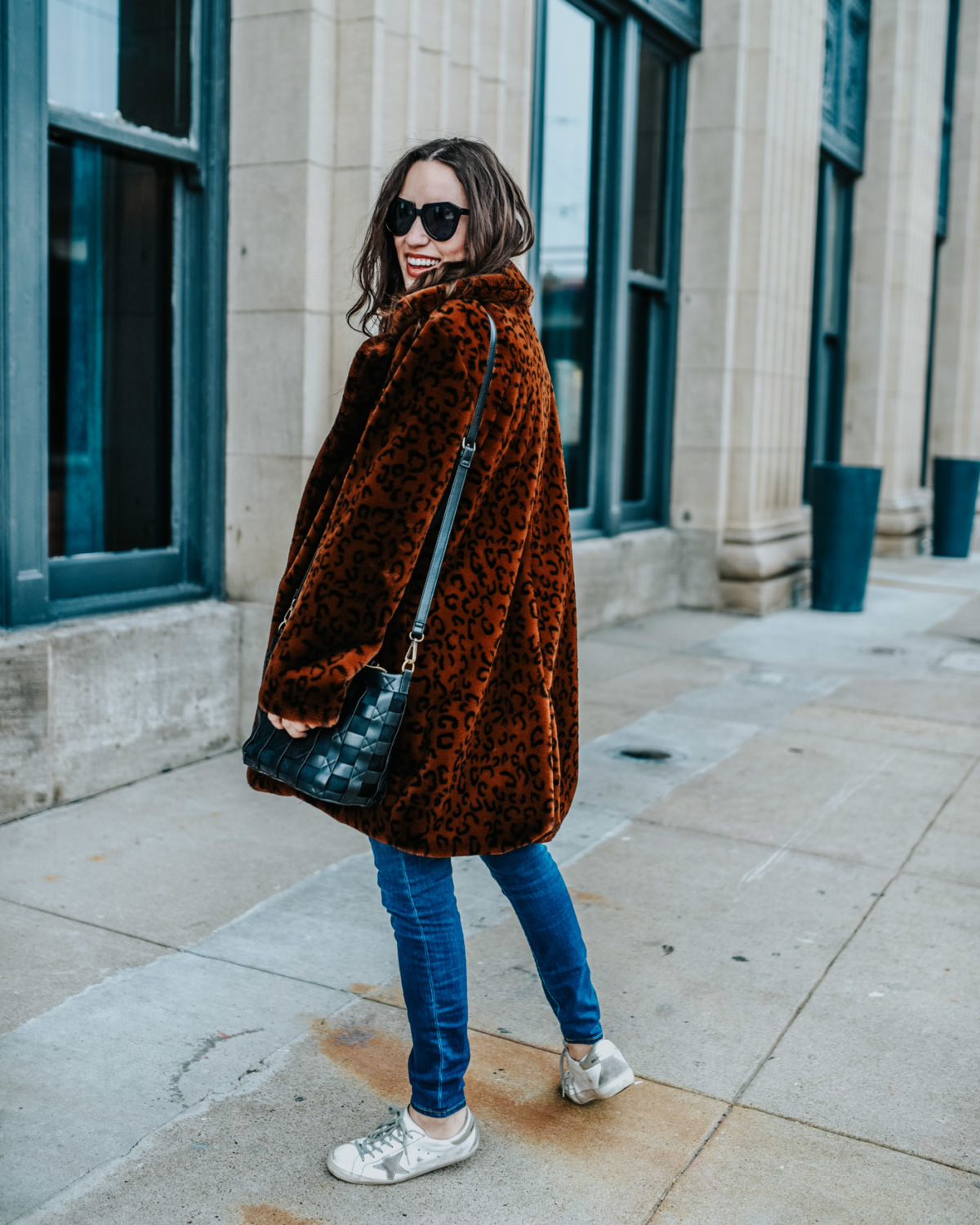 Luxe leopard coat styled down by top US fashion blog, Lone Star Looking Glass: image of a woman wearing a Revolve luxe leopard coat, Golden Goose sneakers and skinny jeans.