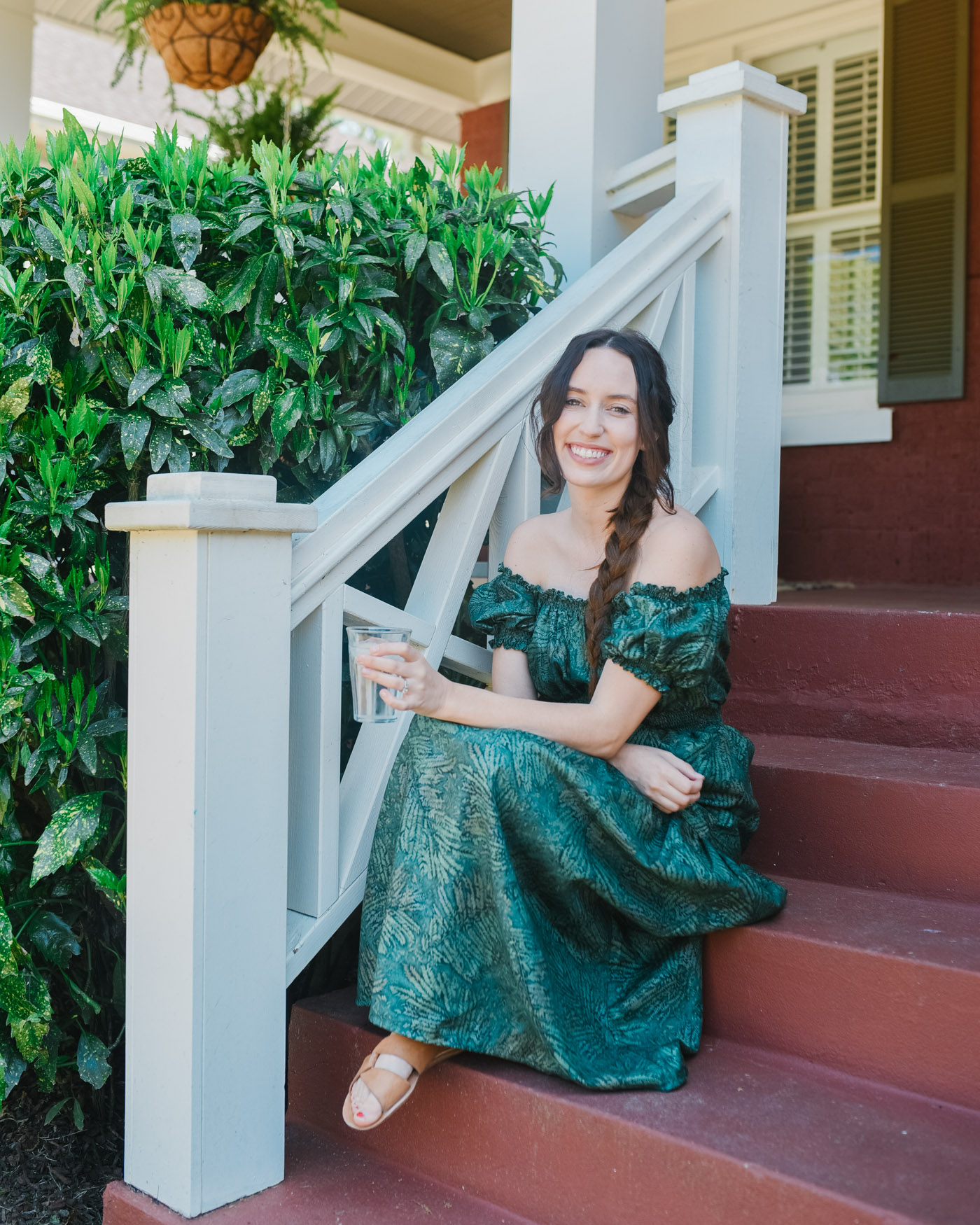 Hunter Fan Company Memphis TN by popular Memphis life and style blog, Lone Star Looking Glass: image of a woman sitting on her front porch and wearing a Free People Nuuly green off the shoulder maxi dress.