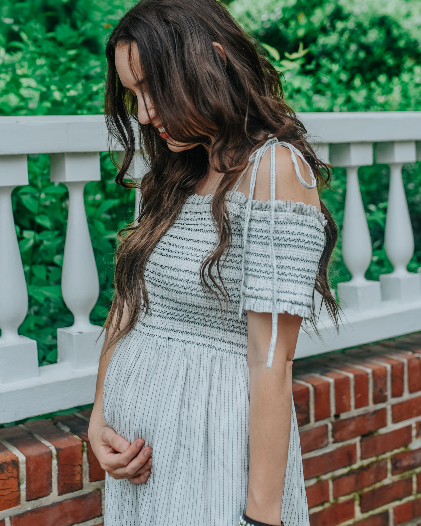 20 Weeks Pregnant _ Spring and Summer Outfit Ideas | 20 Weeks Pregnant Bump by popular Memphis motherhood blog, Lone Star Looking Glass: image of a woman wearing Anthropologie Bernardo Alexis Sandals, Revolve Tallulah Midi Dress Tularosa brand: Tularosa and holding a woven straw bag. 