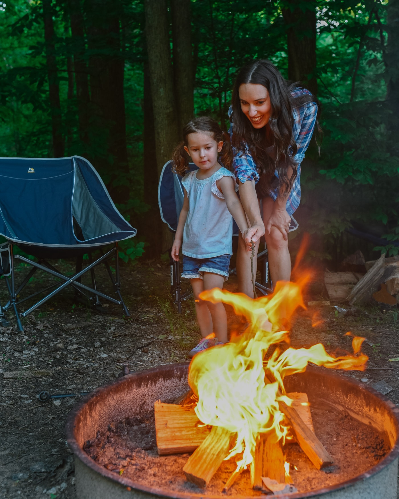 Father's Day Gift Ideas by popular Memphis lifestyle blog, Lone Star Looking Glass: image of a mom and her young daughter standing in front of two Academy pod rocker chairs and roasting marshmallows over a fire. 