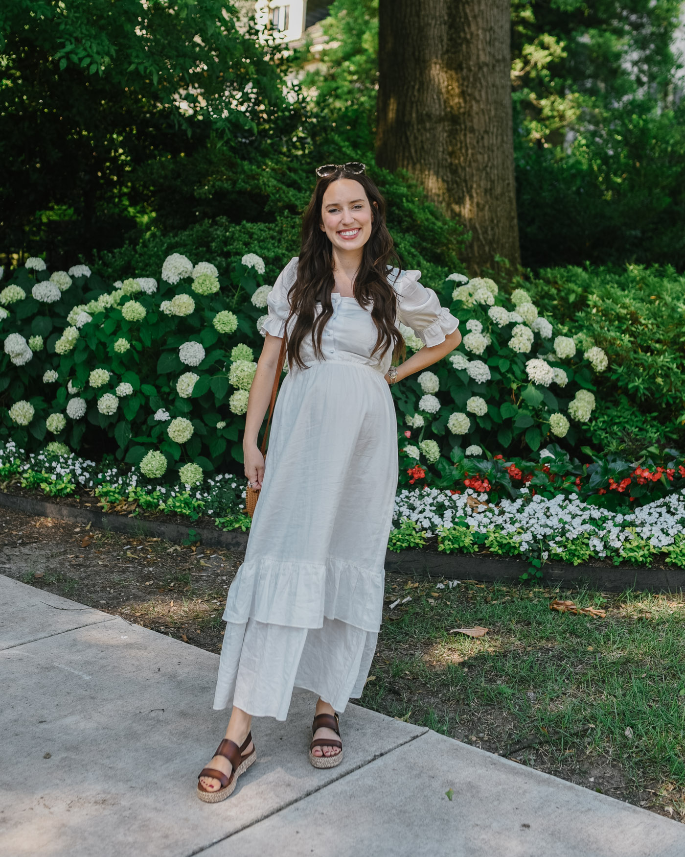 Famous Footwear Sandals by popular Memphis fashion blog, Lone Star Looking Glass: image of a woman wearing a white maxi dress, Famous Footwear WOMEN'S PATIENCE ESPADRILLE PLATFORM SANDAL, and carrying a wicker circle bag. 