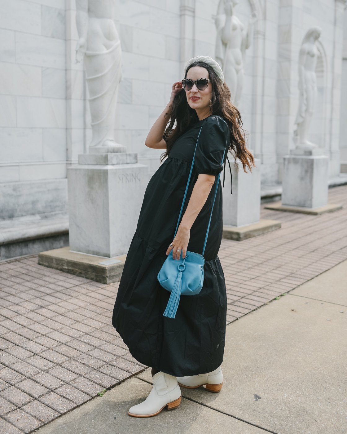 White Cowboy Boots by popular Memphis fashion blog, Lone Star Looking Glass: image of a woman standing outside and wearing a black puff sleeve maxi dress, Amazon Velvet Braided Flock Padded Headband, Hobo BIRDY Crossbody, and white cowboy boots. 