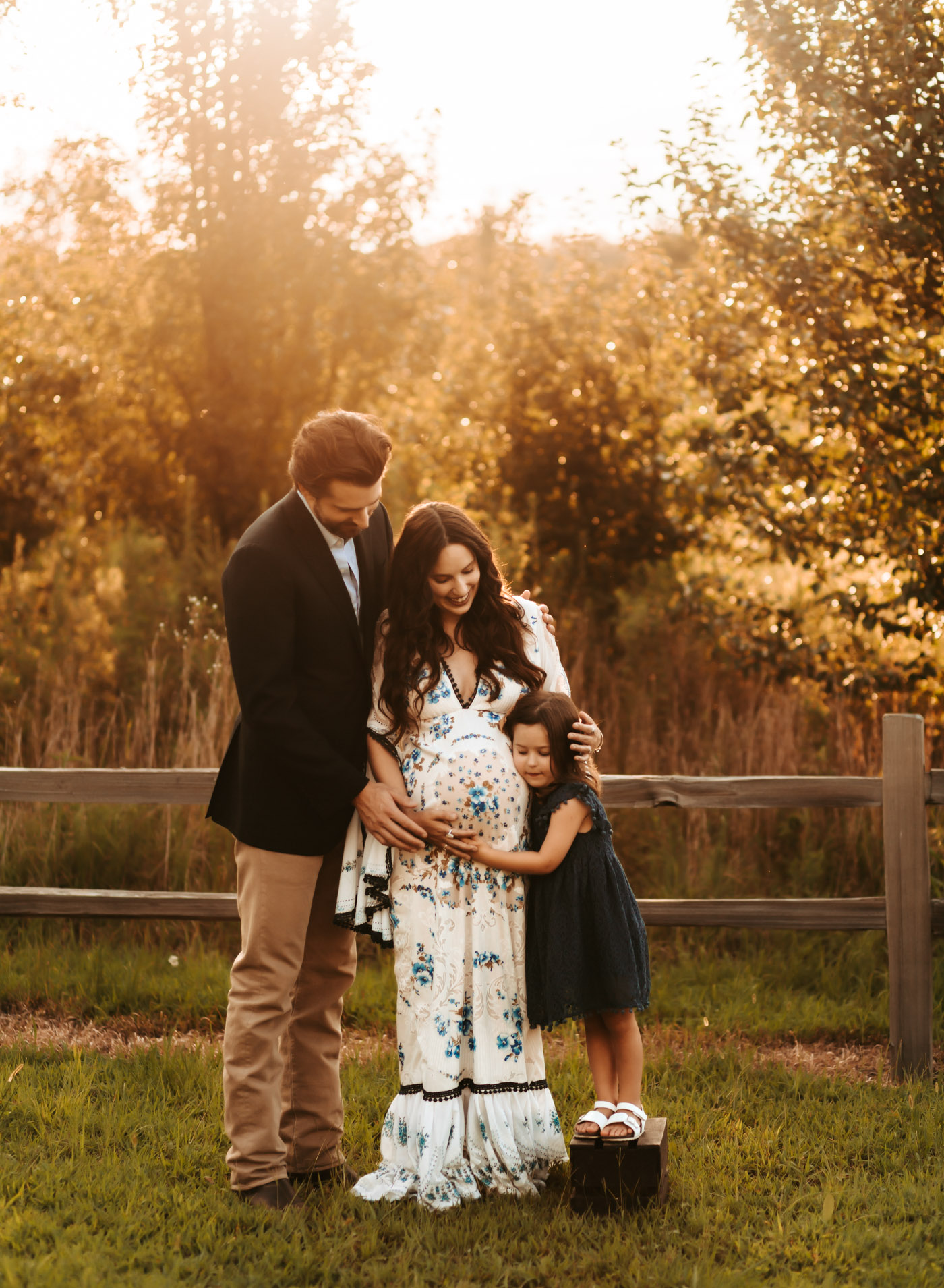 Maternity Photos by popular Memphis motherhood blog, Lone Star Looking Glass: image of a woman wearing a Etsy The Traveling Dress Emily Boho Maternity Dress and Free People Western Cuff Set and standing with her husband and daughter who's wearing a Amazon Niyage Toddler Girls Elegant Lace Pom Pom Flutter Sleeve Party Princess Dress.