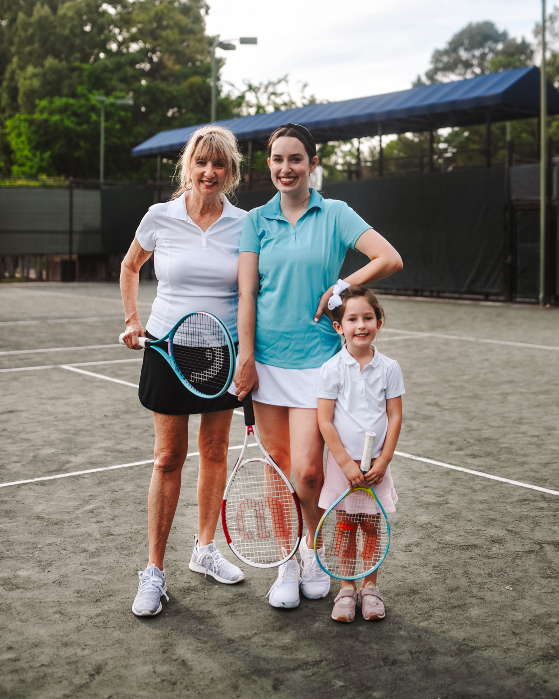 Tennis Outfits by popular Memphis fashion blog, Lone Star Looking Glass: image of three women standing together on a tennis court and holding tennis rackets and wearing tennis outfits. 