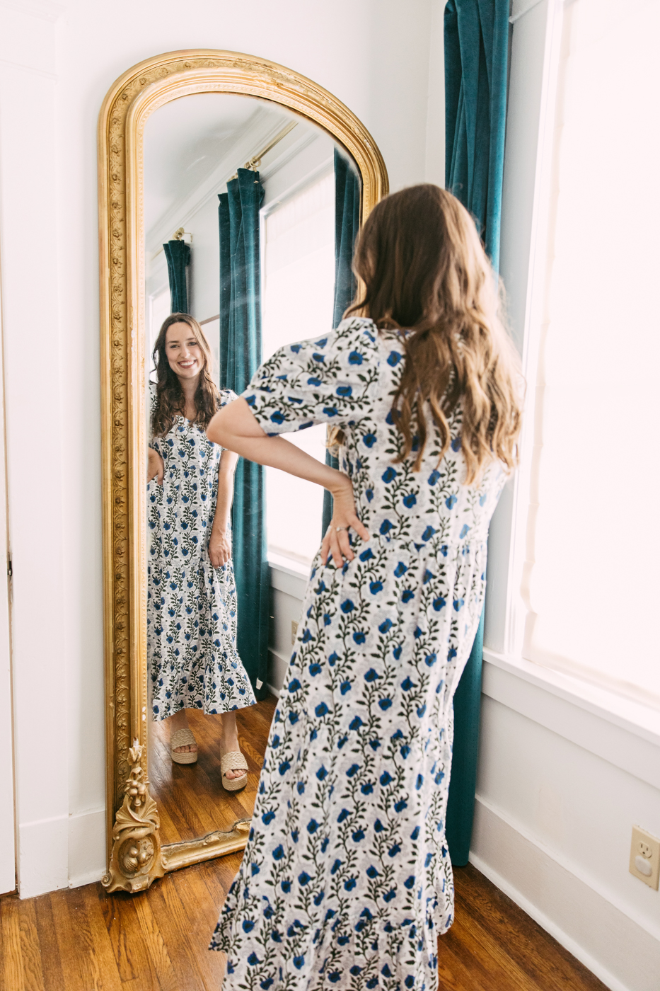 Antique Pier Mirror by popular Memphis life and style blog, Lone Star Looking Glass: image of a woman wearing a blue, grey and white floral maxi dress and looking at herself in a antique pier mirror. 