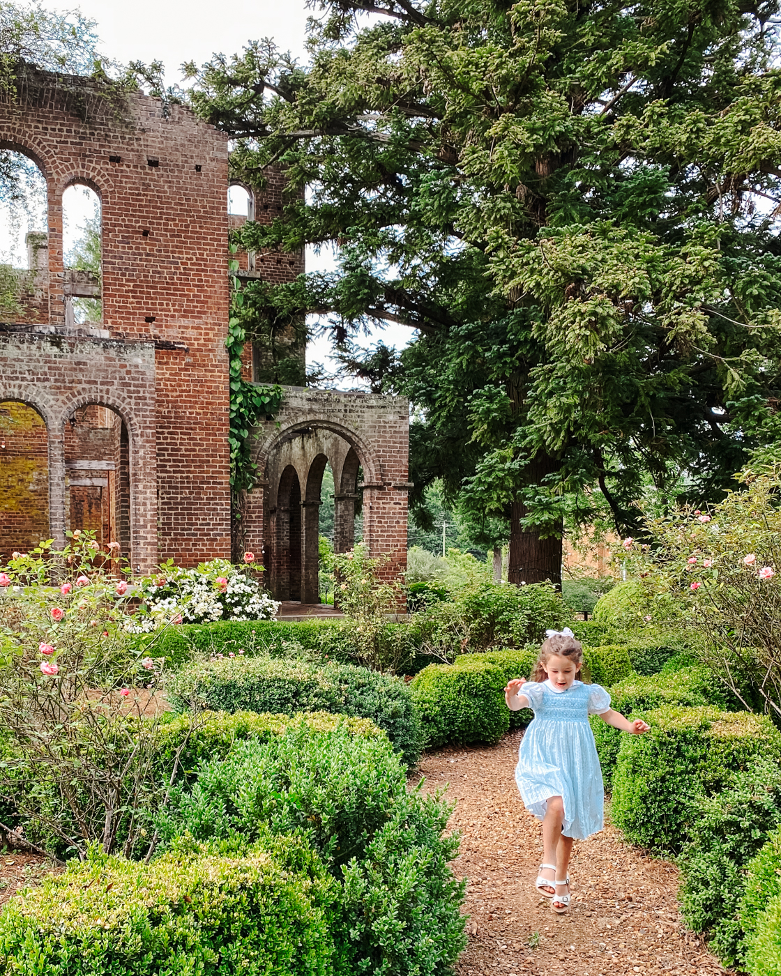 Barnsley Resort by popular Memphis travel blog, Lone Star Looking Glass: image a young girls walking on a gravel path next to some brick manor ruins. 