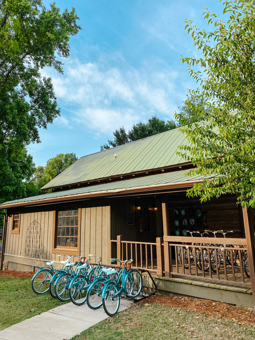 Barnsley Resort by popular Memphis travel blog, Lone Star Looking Glass: image of blue beach cruiser bicycles parked in a row in front of a wooden building with a green metal roof. 