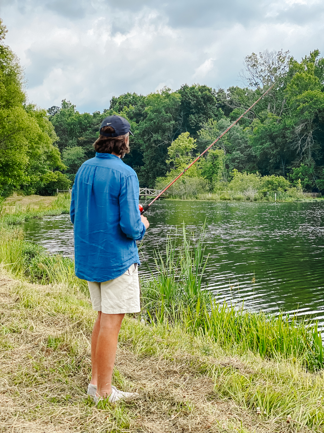 Barnsley Resort by popular Memphis travel blog, Lone Star Looking Glass: image of a man fishing on the grassy shore of a lake. 
