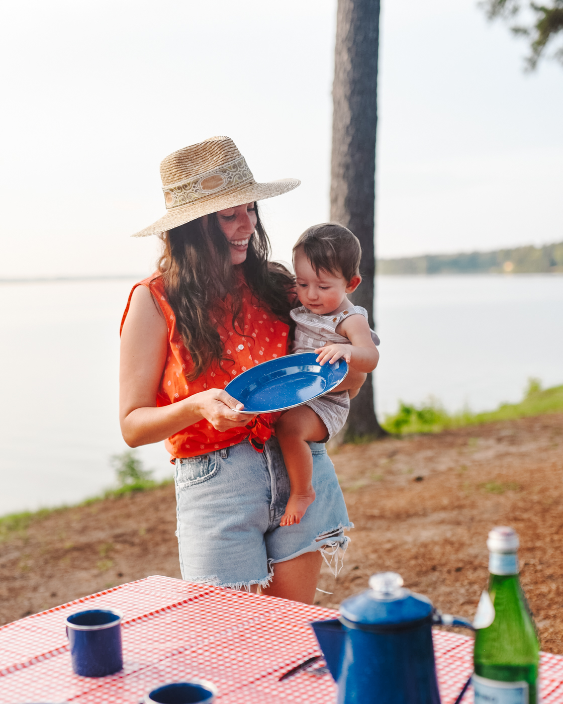 Camping With Kids by popular Memphis lifestyle blog, Lone Star Looking Glass: image of a mom holding her young son and a blue metal plate. 