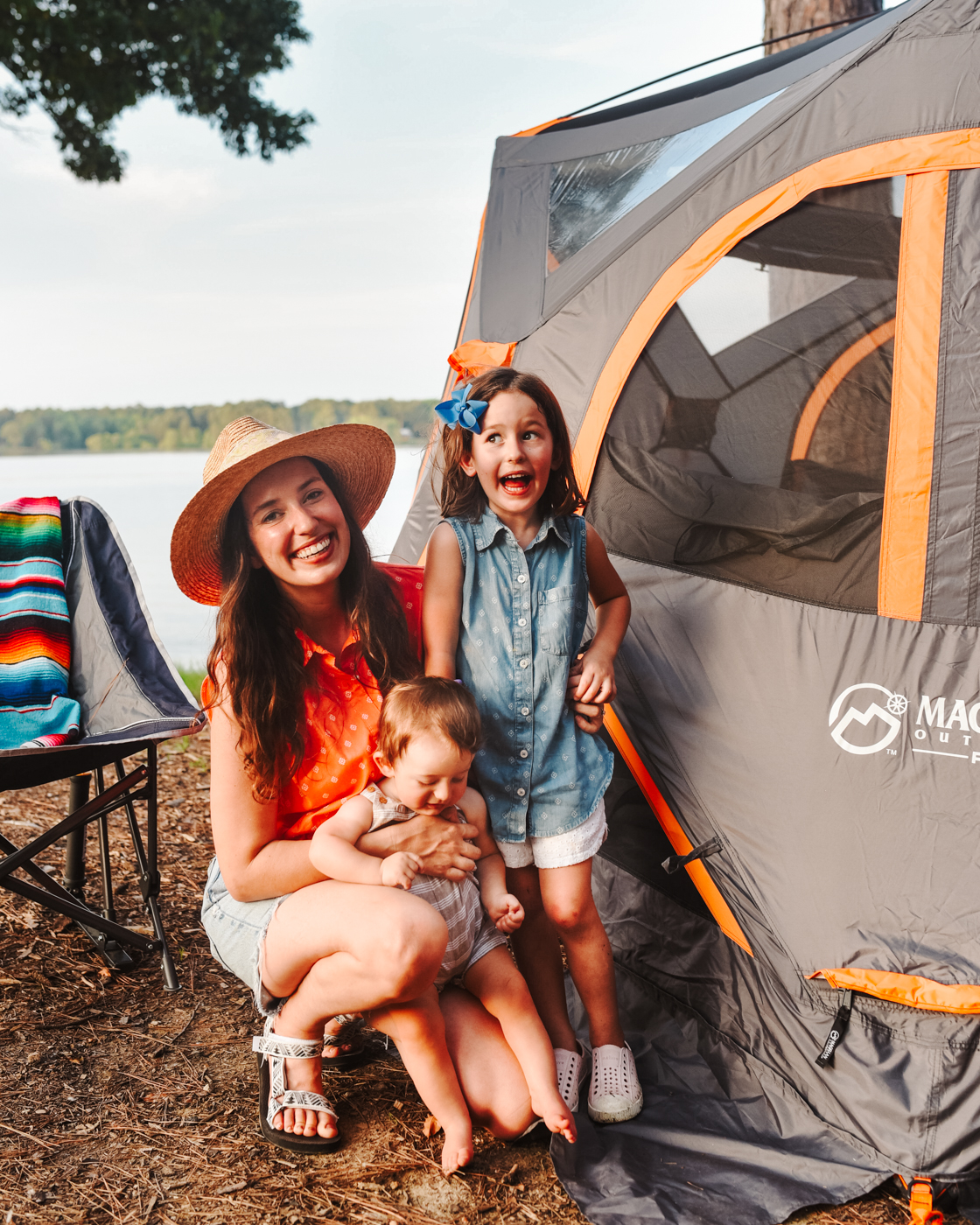 Camping With Kids by popular Memphis lifestyle blog, Lone Star Looking Glass: image of a mom and her young daughter and son standing next to their Magellan tent. 