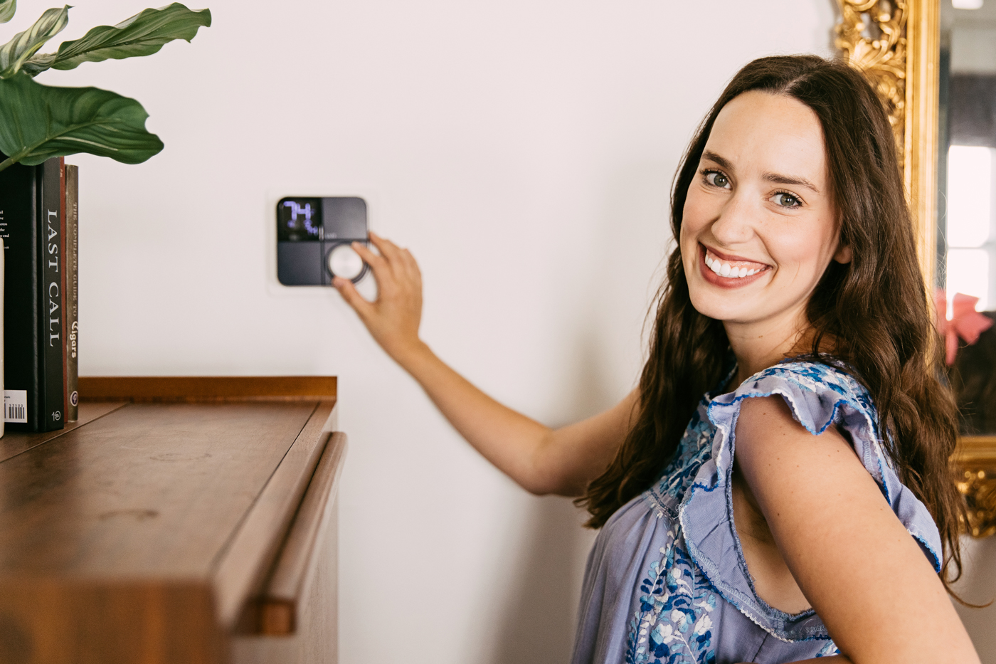 Lux Kono Smart Thermostat by popular Memphis lifestyle blog: image of a woman adjusting her Lux Kono smart thermostat. 