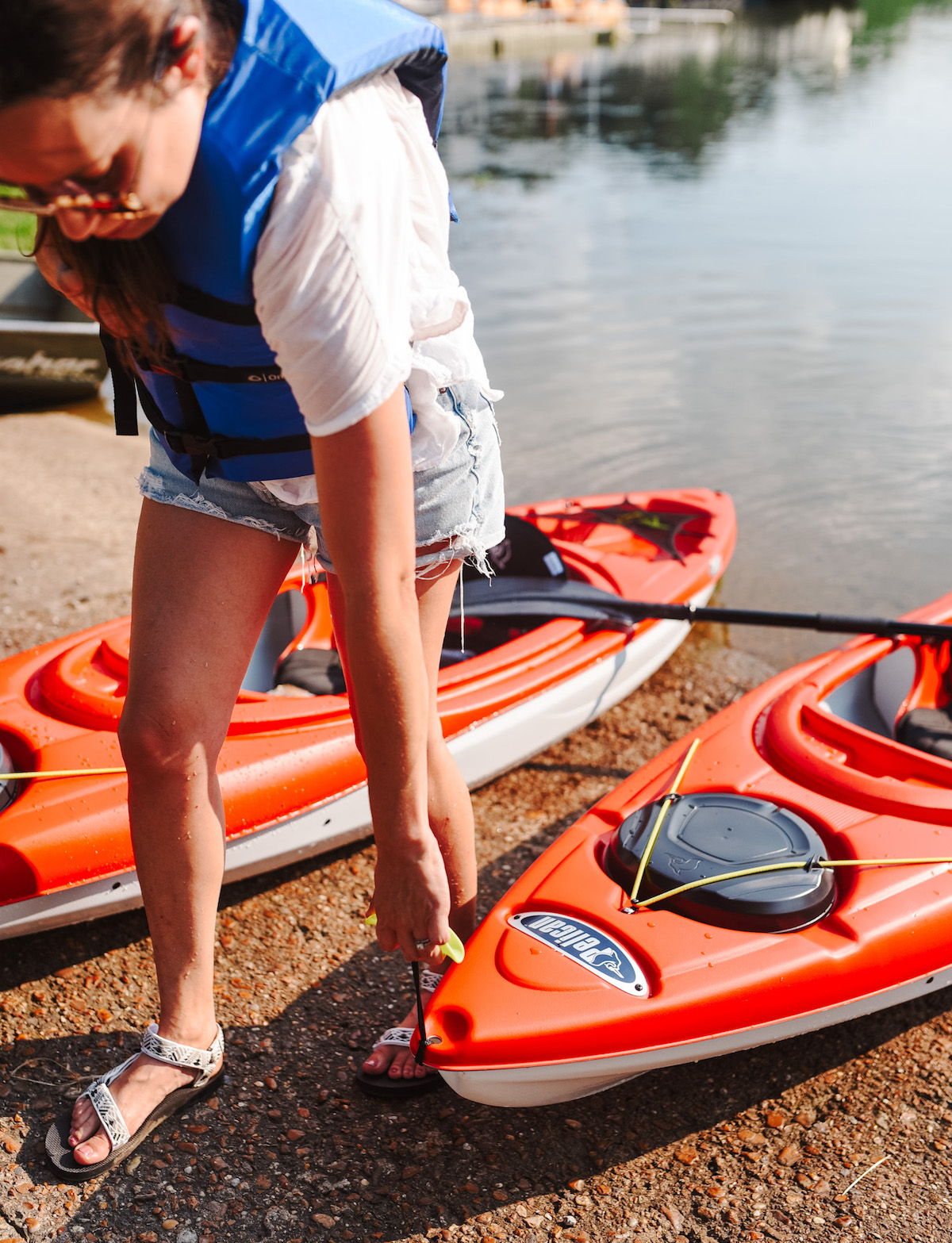 Kayaking for Beginners by poplar Memphis lifestyle blog, Lone Star Looking Glass: image of a woman pulling a red kayak out of a lake. 