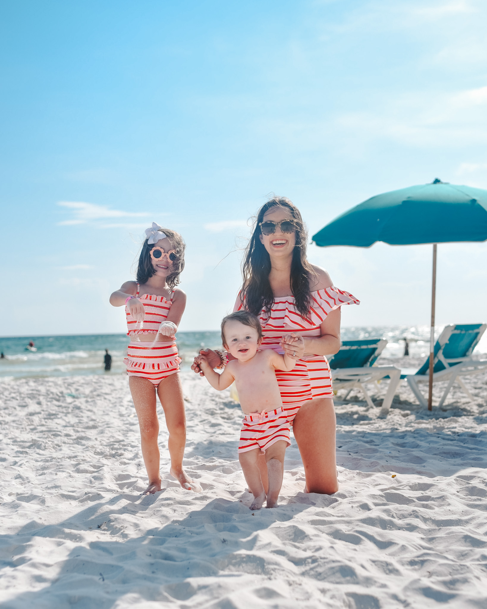 Panama City Beach Attractions by popular Memphis travel blog, Lone Star Looking Glass: image of a mom and her young son and daughter wearing matching orange and white stripe swimsuits on Panama City Beach. 