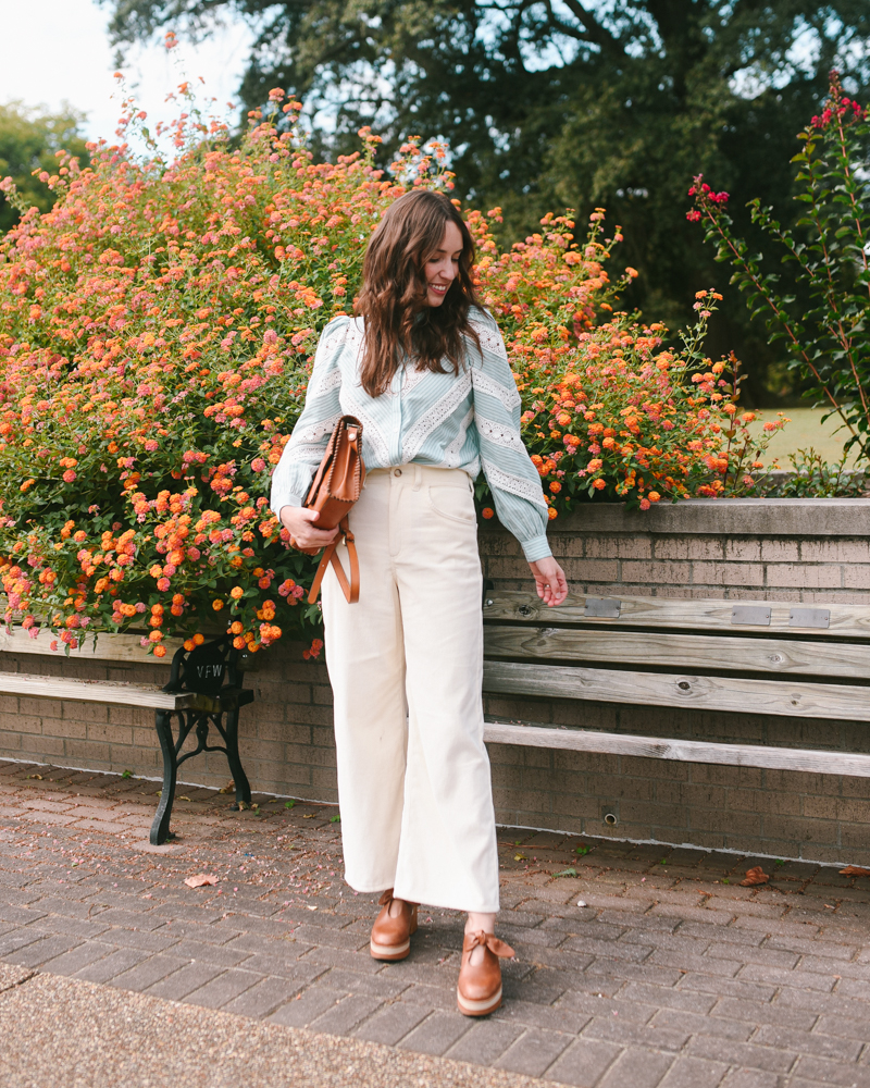 Sezane fall outfit - white pants with a blue blouse and vintage-inspired handbag