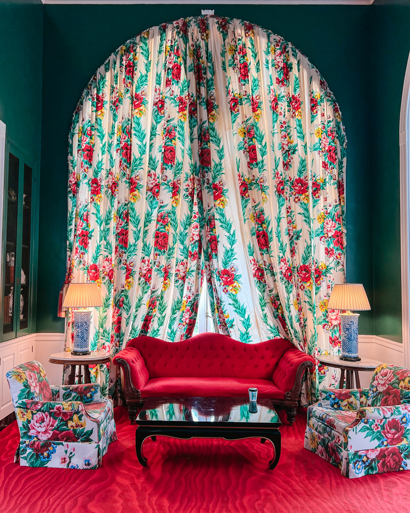 The Greenbrier’s iconic Dorothy Draper floral curtains and red velvet sofa — a timeless example of colorful Southern interior design.